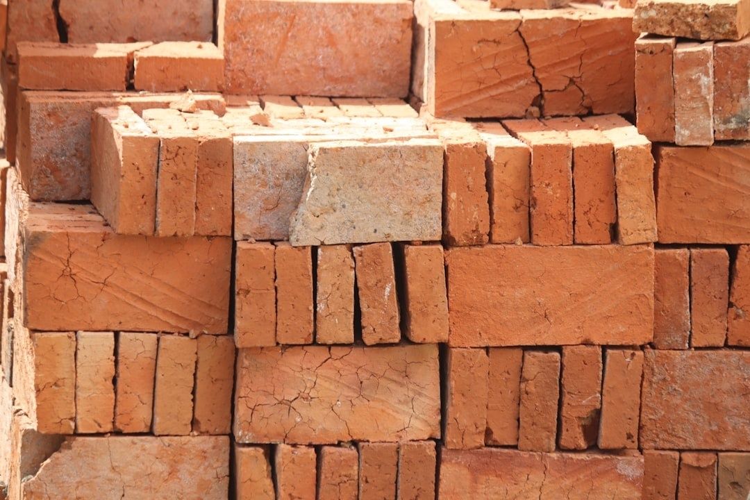 Staplar av slitna, spruckna tegelstenar som byggmaterial